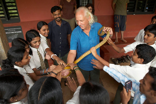 Rom Whitaker showing a harmless rat snake to Agumbe school children