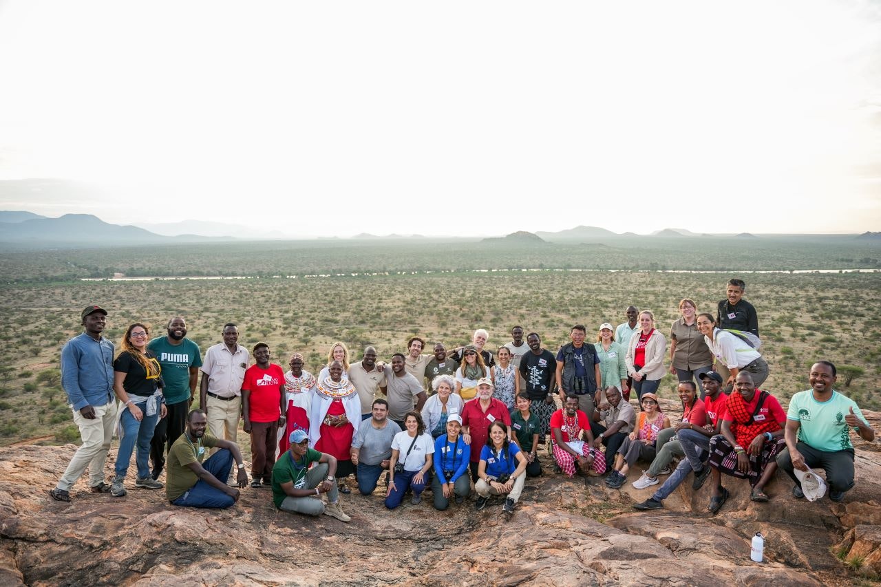 A group portrait of workshop participants standing with their back to a beautiful view